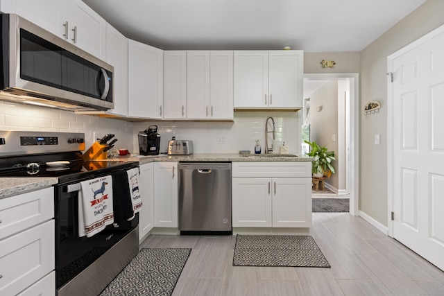 152 Lincoln St Unit 17, Waterbury, CT 06710 - kitchen with stainless steel appliances, tasteful backsplash, and white cabinetry