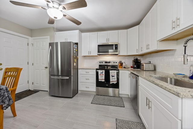 152 Lincoln St Unit 17, Waterbury, CT 06710 - kitchen featuring appliances with stainless steel finishes, a ceiling fan, tasteful backsplash, and white cabinetry
