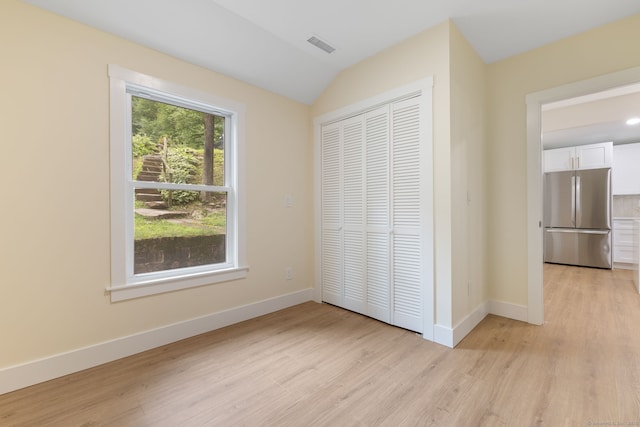 145 Lakeview Dr, Colchester, CT 06415 - unfurnished bedroom featuring freestanding refrigerator, light wood-style floors, a closet, and lofted ceiling