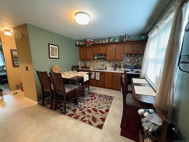 80 Beths Ave Apt 3, Bristol, CT 06010 - kitchen with range with electric stovetop, tasteful backsplash, light countertops, and brown cabinets