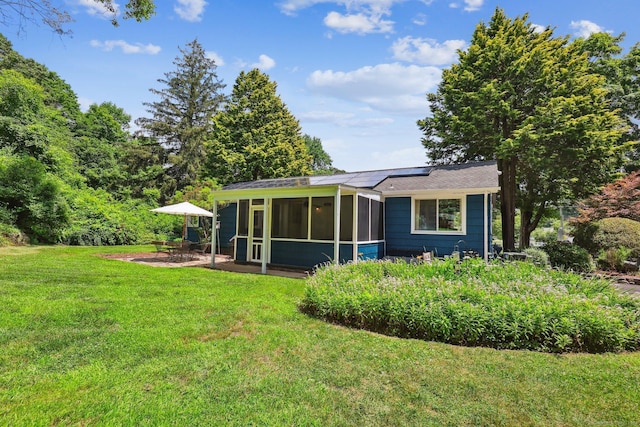 103 Glenwood Rd, Clinton, CT 06413 - back of house with a sunroom, a yard, roof mounted solar panels, and a patio