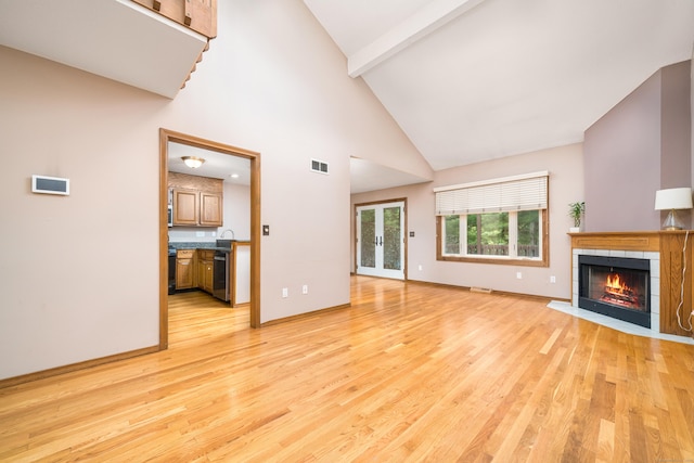 34 Cortland Way Unit 34, Newington, CT 06111 - unfurnished living room featuring a tile fireplace, light wood finished floors, high vaulted ceiling, and beam ceiling