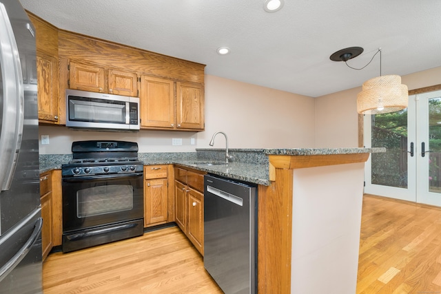34 Cortland Way Unit 34, Newington, CT 06111 - kitchen with appliances with stainless steel finishes, a peninsula, light wood-style floors, french doors, and brown cabinets