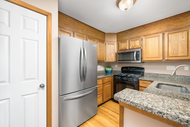 34 Cortland Way Unit 34, Newington, CT 06111 - kitchen featuring appliances with stainless steel finishes, light wood finished floors, stone countertops, and a textured ceiling
