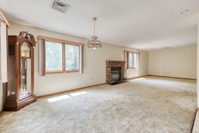 120 Songbird Ln Unit 120, Farmington, CT 06032 - unfurnished living room featuring carpet, a brick fireplace, a textured ceiling, and a chandelier