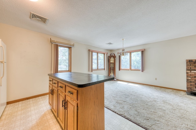 120 Songbird Ln Unit 120, Farmington, CT 06032 - kitchen featuring dark countertops, plenty of natural light, a textured ceiling, a kitchen island, and open floor plan