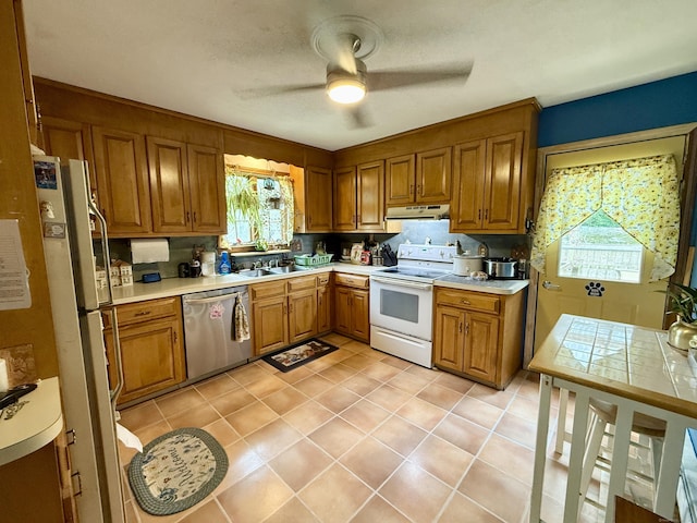 18 Booth Rd, Enfield, CT 06082 - kitchen featuring white appliances, under cabinet range hood, brown cabinetry, ceiling fan, and light countertops