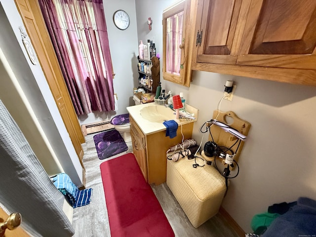 18 Booth Rd, Enfield, CT 06082 - bathroom with vanity, baseboard heating, and wood finished floors