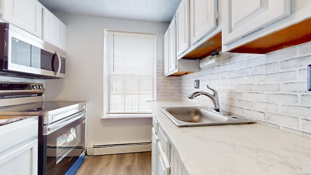64 Van Block Ave Unit 9B, Hartford, CT 06106 - kitchen with appliances with stainless steel finishes, light wood-style flooring, white cabinets, and a baseboard radiator