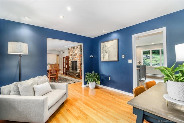 10 Fernbrook Dr, Brookfield, CT 06804 - living area featuring wood finished floors, a baseboard radiator, a stone fireplace, and recessed lighting