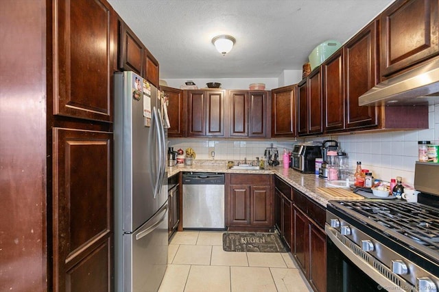11 Bedford Ave Apt J2, Norwalk, CT 06850 - kitchen with stainless steel appliances, under cabinet range hood, decorative backsplash, and light tile patterned floors
