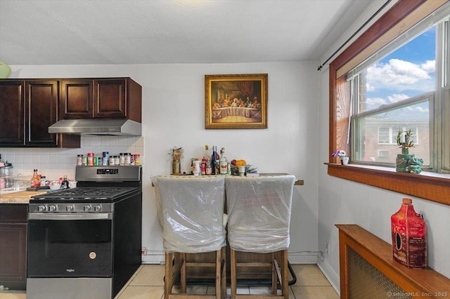 11 Bedford Ave Apt J2, Norwalk, CT 06850 - kitchen with gas stove, light tile patterned floors, under cabinet range hood, and healthy amount of natural light