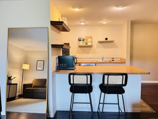 110 Trolley Crossing Ln Unit 110, Middletown, CT 06457 - kitchen with open shelves, dark wood-type flooring, a peninsula, a breakfast bar, and black microwave