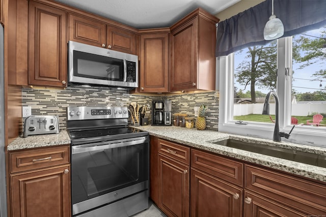 15 Arlington Rd, Windsor Locks, CT 06096 - kitchen featuring appliances with stainless steel finishes, backsplash, light stone counters, and brown cabinets