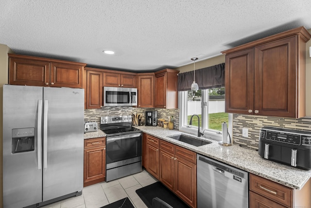 15 Arlington Rd, Windsor Locks, CT 06096 - kitchen featuring appliances with stainless steel finishes, decorative backsplash, light stone counters, light tile patterned floors, and a textured ceiling