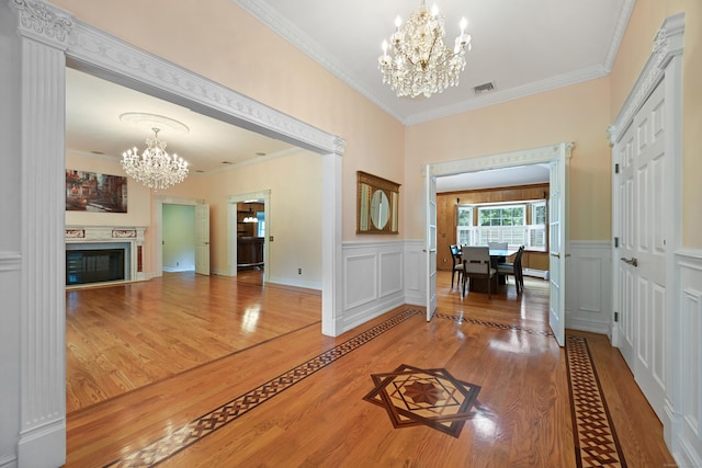 9 Old Logging Rd, Stamford, CT 06903 - entryway with a chandelier, wood finished floors, ornamental molding, wainscoting, and a glass covered fireplace