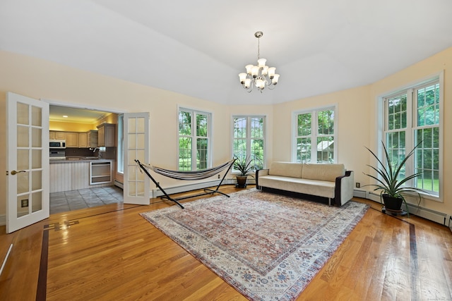 9 Old Logging Rd, Stamford, CT 06903 - living area with light wood finished floors, a chandelier, and a baseboard heating unit
