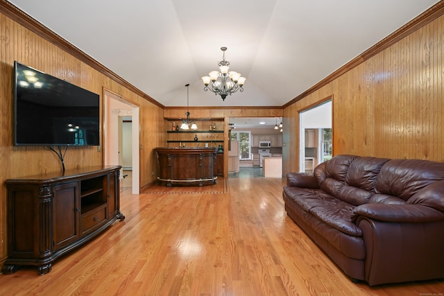 9 Old Logging Rd, Stamford, CT 06903 - living area featuring a chandelier, lofted ceiling, wooden walls, ornamental molding, and light wood-style flooring