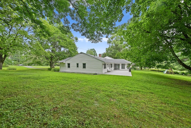9 Old Logging Rd, Stamford, CT 06903 - back of property featuring a patio, a lawn, and a chimney