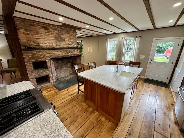 37 Lane St, Shelton, CT 06484 - kitchen with a brick fireplace, light wood finished floors, beamed ceiling, brown cabinets, and light countertops