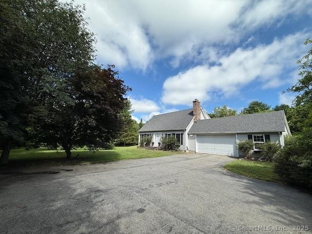 67 Bergendahl Dr, Griswold, CT 06351 - view of front of home with a garage, a front lawn, asphalt driveway, and a chimney