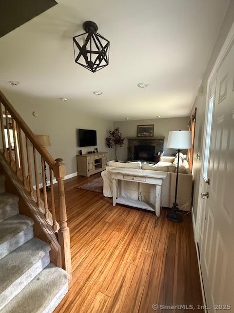 67 Bergendahl Dr, Griswold, CT 06351 - living area with stairway, light wood-type flooring, and a fireplace