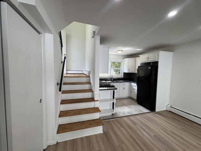 10 Willowbrook Ct Unit 10, Stamford, CT 06902 - kitchen with freestanding refrigerator, light wood-style floors, dark countertops, white cabinetry, and tasteful backsplash