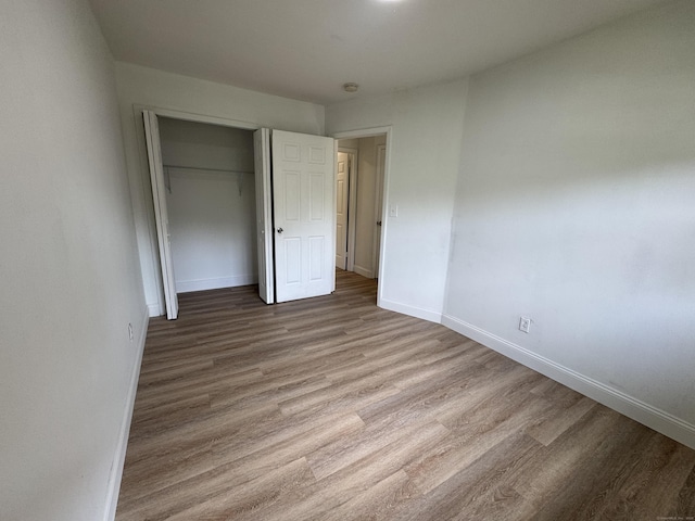 10 Willowbrook Ct Unit 10, Stamford, CT 06902 - unfurnished bedroom featuring wood finished floors and a closet