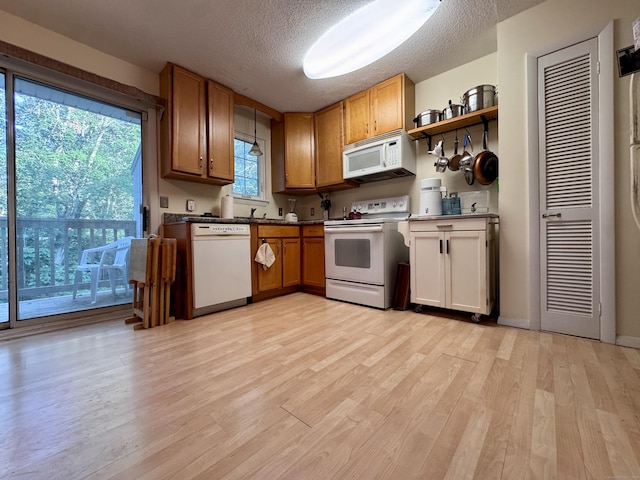 92 Cynthia Ln Apt E1, Middletown, CT 06457 - kitchen featuring white appliances, light wood-style floors, a textured ceiling, brown cabinets, and open shelves