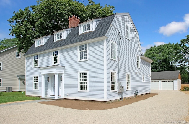 65 Water St, Guilford, CT 06437 - view of front of home with a gambrel roof, an outbuilding, a chimney, a shingled roof, and a garage