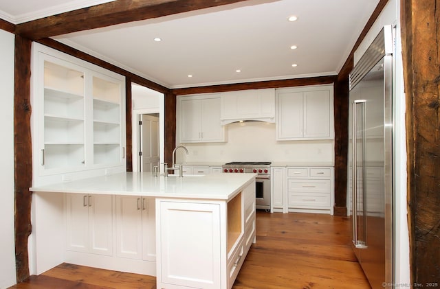 65 Water St, Guilford, CT 06437 - kitchen featuring a peninsula, high quality appliances, light countertops, crown molding, and white cabinets