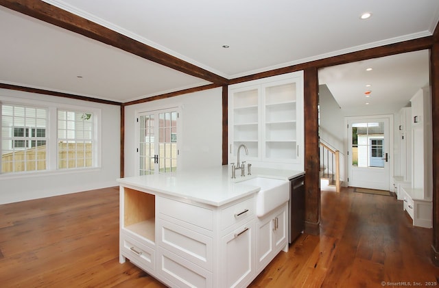65 Water St, Guilford, CT 06437 - kitchen featuring wood finished floors, white cabinetry, light countertops, glass insert cabinets, and stainless steel dishwasher