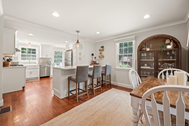 73 Water St, Glastonbury, CT 06073 - kitchen featuring white cabinets, a kitchen breakfast bar, light countertops, wood finished floors, and recessed lighting