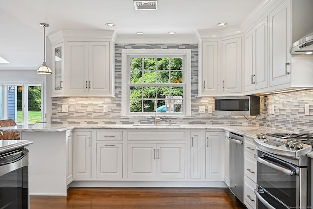 68 William St, Norwalk, CT 06851 - kitchen with appliances with stainless steel finishes, white cabinetry, decorative backsplash, hanging light fixtures, and recessed lighting