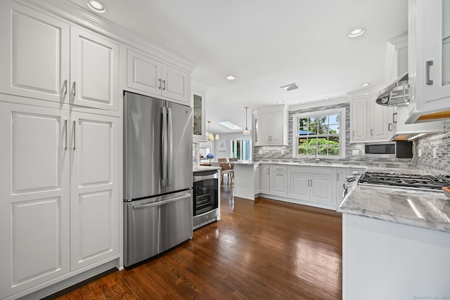 68 William St, Norwalk, CT 06851 - kitchen with freestanding refrigerator, white cabinets, backsplash, and recessed lighting