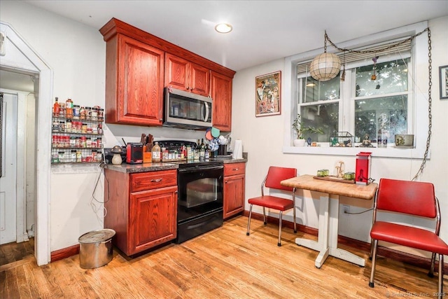 52 Hudson Dr, New Fairfield, CT 06812 - kitchen with black range with electric stovetop, stainless steel microwave, and light wood-style floors