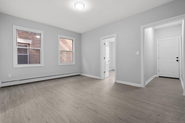 276 Bond St, Bridgeport, CT 06610 - empty room with baseboard heating, wood finished floors, and a baseboard heating unit