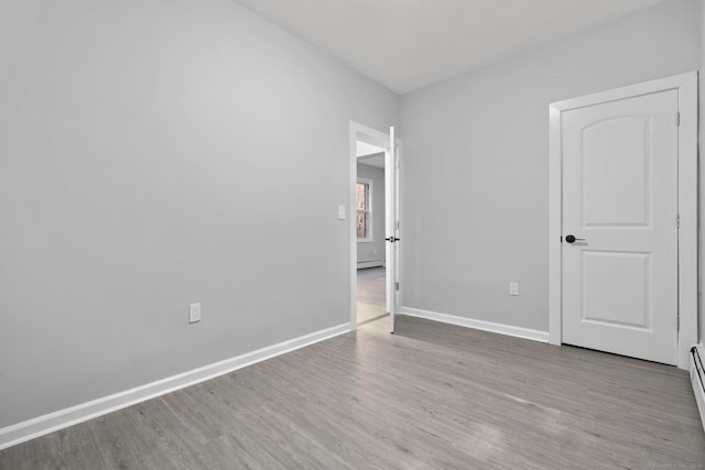 276 Bond St, Bridgeport, CT 06610 - unfurnished bedroom with wood finished floors and a baseboard radiator