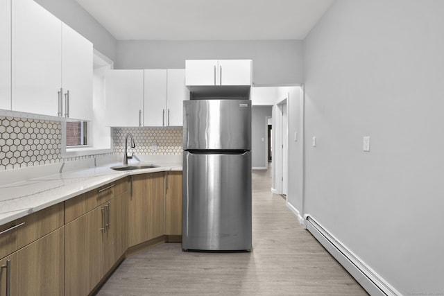 276 Bond St, Bridgeport, CT 06610 - kitchen featuring freestanding refrigerator, baseboard heating, white cabinetry, light wood-style flooring, and backsplash