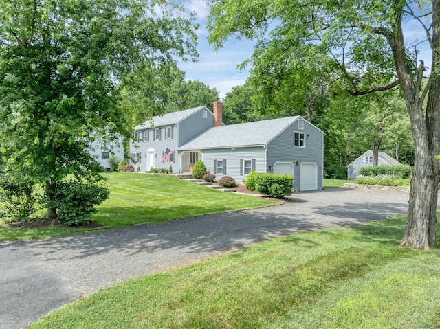 35 Pheasant Ln, Ridgefield, CT 06877 - colonial-style house featuring gravel driveway, an attached garage, a chimney, and a front lawn