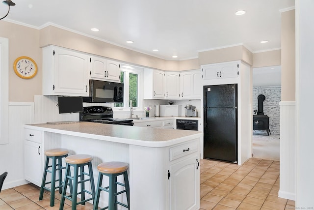 35 Pheasant Ln, Ridgefield, CT 06877 - kitchen featuring black appliances, a peninsula, white cabinetry, light tile patterned floors, and a breakfast bar