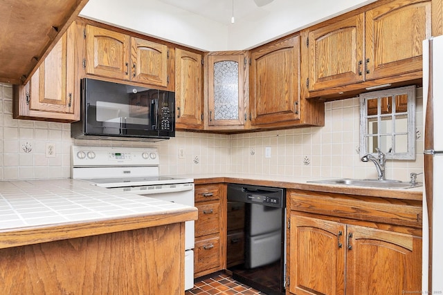 35 Pheasant Ln, Ridgefield, CT 06877 - kitchen with black appliances, backsplash, tile counters, and brown cabinetry