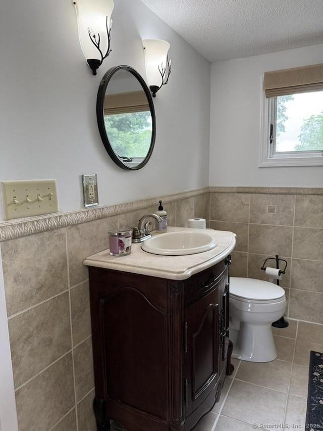19 Hartford Ave, Old Saybrook, CT 06475 - bathroom with tile walls, vanity, tile patterned floors, wainscoting, and a textured ceiling