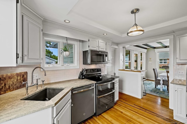 8 Fenbrook Rd, Old Saybrook, CT 06475 - kitchen with appliances with stainless steel finishes, light wood-style flooring, tasteful backsplash, decorative light fixtures, and light stone countertops