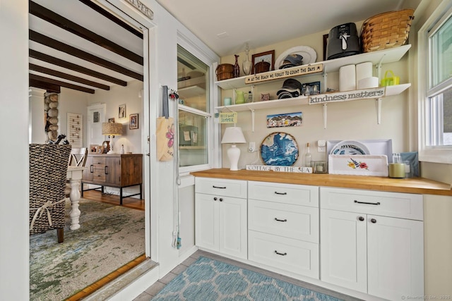 8 Fenbrook Rd, Old Saybrook, CT 06475 - kitchen with butcher block counters, open shelves, white cabinets, beam ceiling, and light tile patterned floors