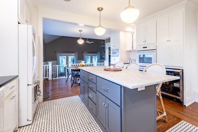 336 Main St, Wethersfield, CT 06109 - kitchen with white appliances, beverage cooler, white cabinets, a breakfast bar area, and lofted ceiling