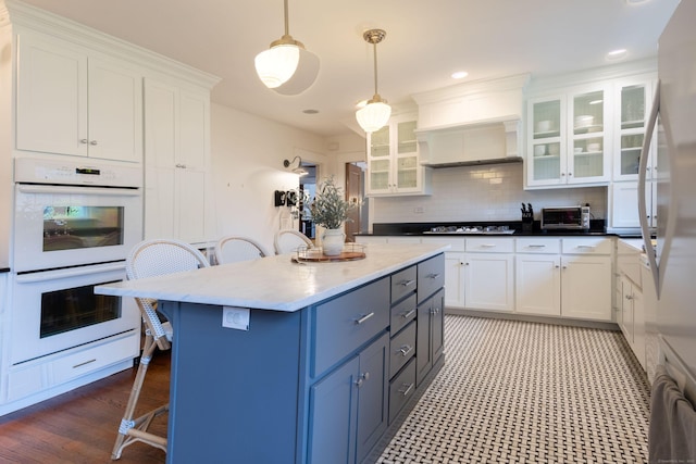 336 Main St, Wethersfield, CT 06109 - kitchen with double oven, a breakfast bar, white cabinetry, cooktop, and recessed lighting