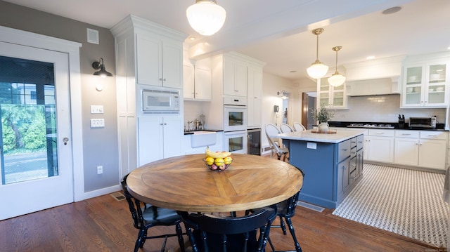 336 Main St, Wethersfield, CT 06109 - kitchen featuring white appliances, white cabinetry, backsplash, and a kitchen island
