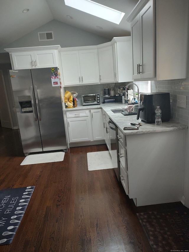 191 Dawson Ave, West Haven, CT 06516 - kitchen featuring stainless steel appliances, a skylight, dark wood finished floors, light countertops, and lofted ceiling