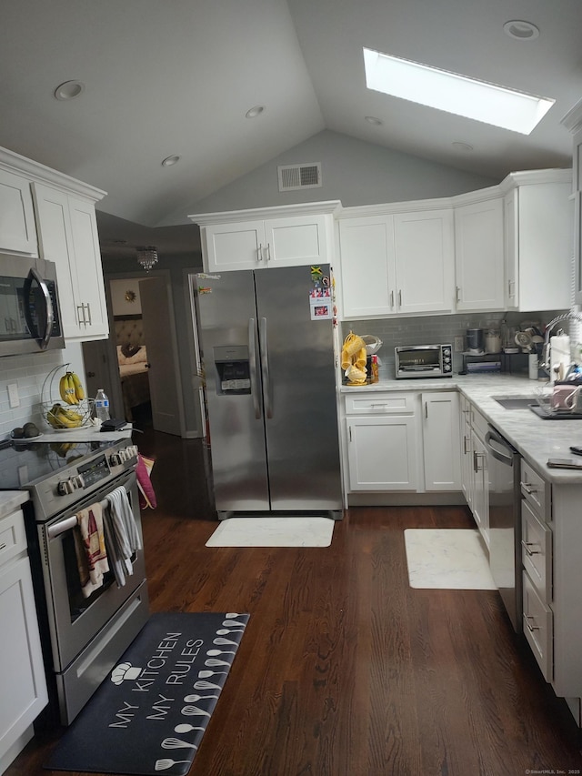 191 Dawson Ave, West Haven, CT 06516 - kitchen featuring appliances with stainless steel finishes, a skylight, lofted ceiling, light countertops, and white cabinets